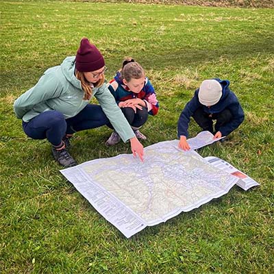An adult and two children looking at a map