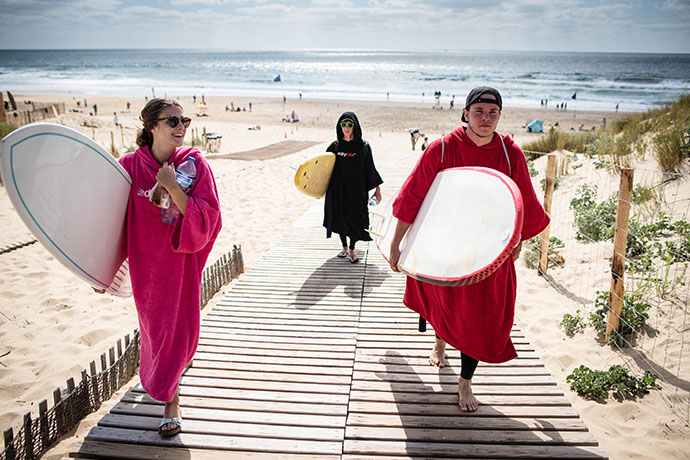 People wearing dryrobes on a beach